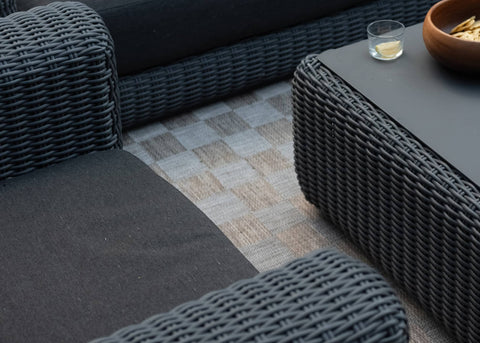 Overhead view of outdoor wicker sofa and coffee table loaded with snacks