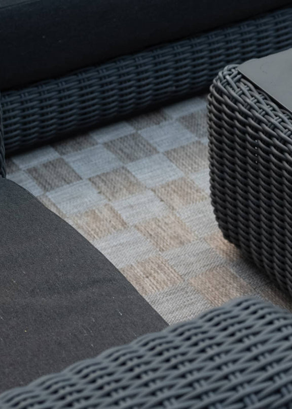 Overhead view of outdoor wicker sofa and coffee table loaded with snacks