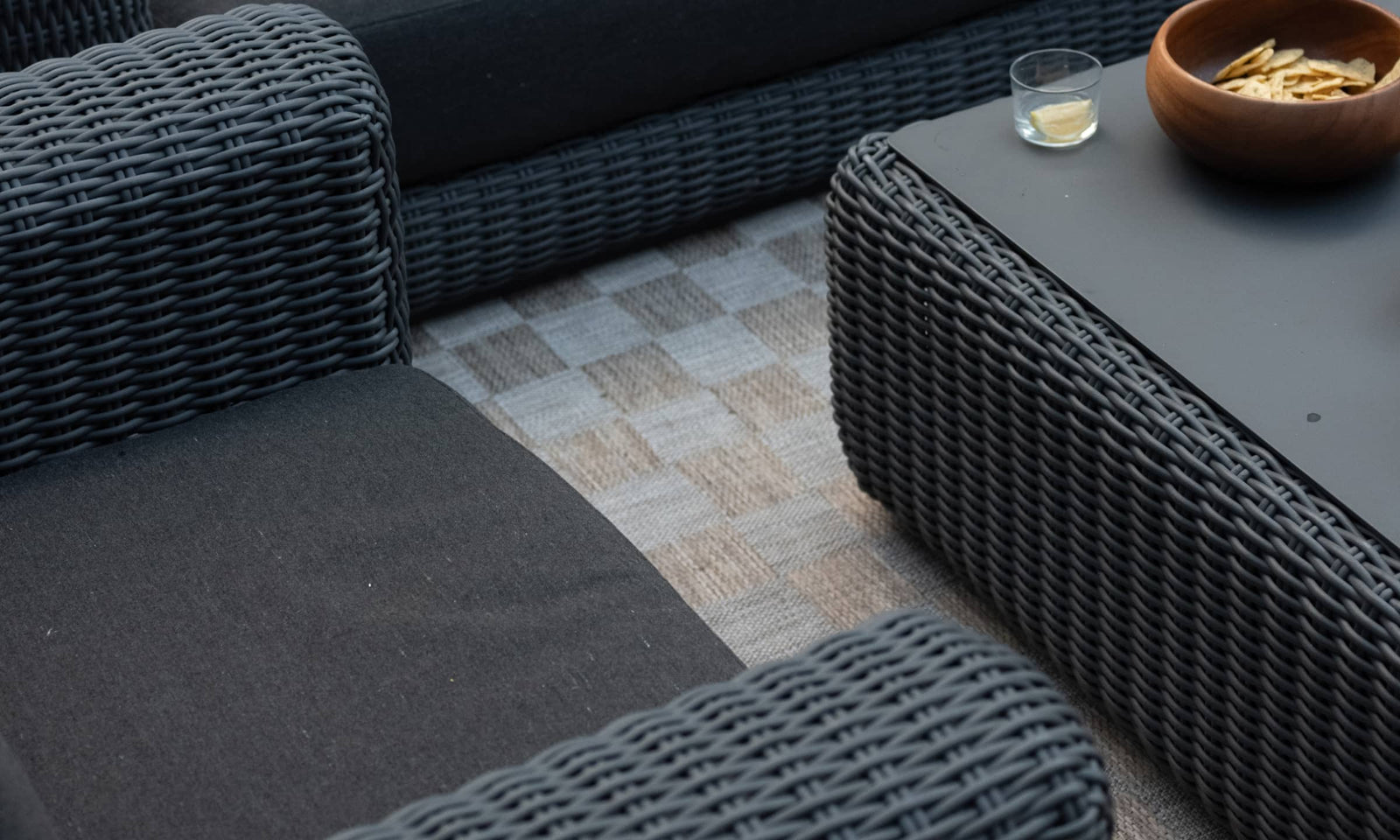 Overhead view of outdoor wicker sofa and coffee table loaded with snacks