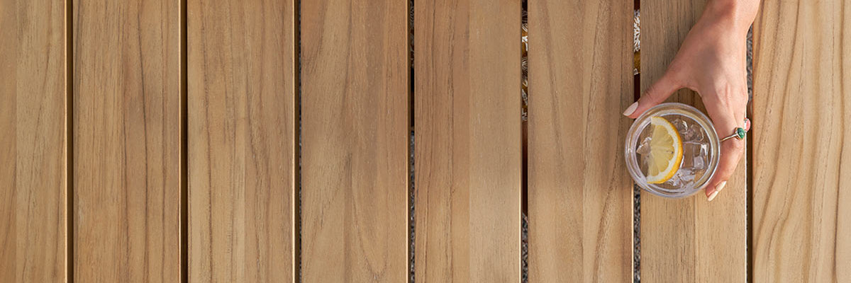 Glass of lemon water on a Neighbor teak outdoor dining table 