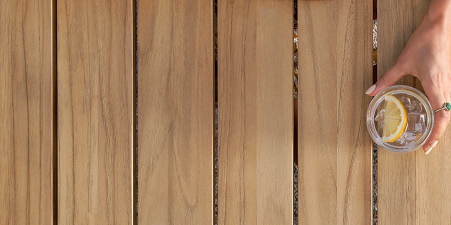 Glass of lemon water on a Neighbor teak outdoor dining table 