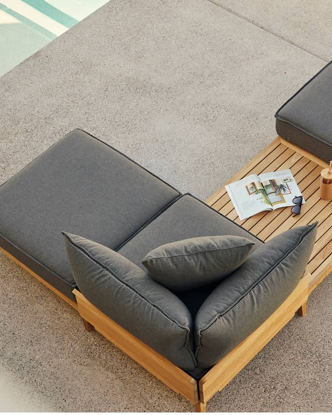 Overhead view of outdoor gray chaise lounge chair with teak frame near pool edge