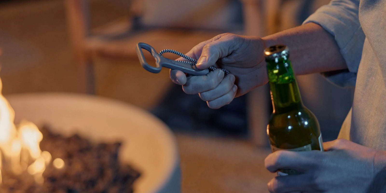 Closeup of Neighbor Rook Round fire table lava rocks and flame in evening outdoor setting