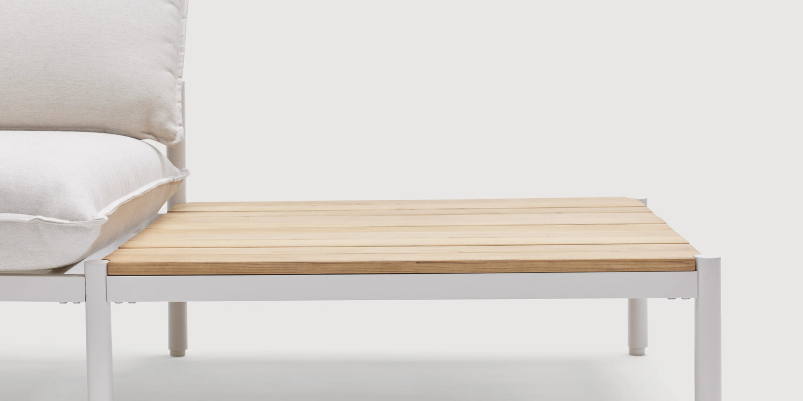 Two women conversing on Neighbor Terra Sectional with End Table in cream fabric and teak on covered patio