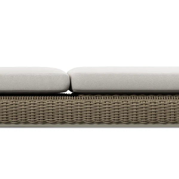 Tight side-elevation product shot of the thick two-piece cream cushion seated on the taupe-gray resin-wicker frame of a Neighbor Roundabout Sun Lounger, isolated on a white background to highlight cushion depth and weave detail.