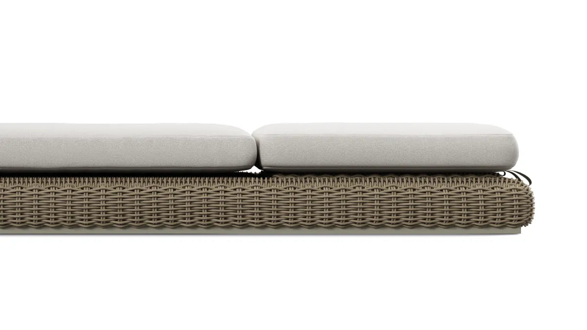 Tight side-elevation product shot of the thick two-piece cream cushion seated on the taupe-gray resin-wicker frame of a Neighbor Roundabout Sun Lounger, isolated on a white background to highlight cushion depth and weave detail.
