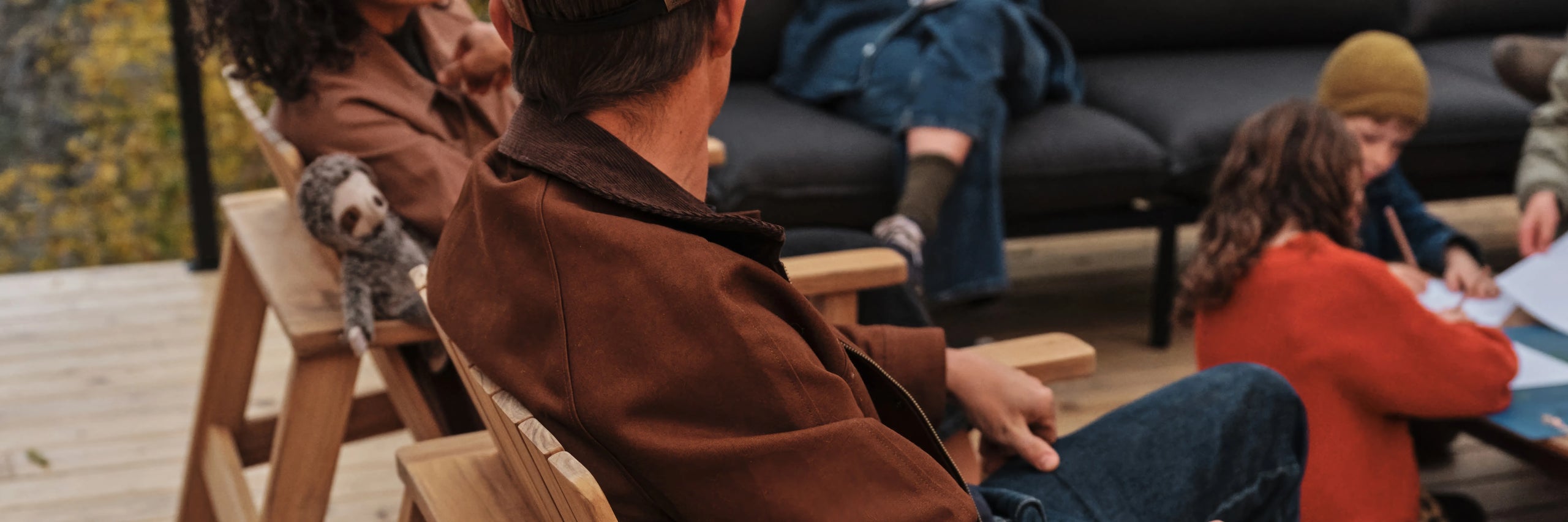 People sitting outdoors on a wooden bench with a scenic background