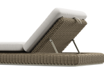Neighbor Roundabout Sun Lounger with woven all-weather wicker base and a thick cushion, shown in articulated position with the backrest raised, cushion shown in natural wicker tan, low-angle detail view.