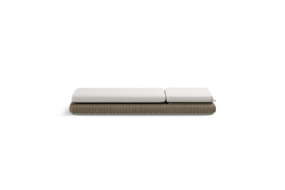 Neighbor Roundabout Sun Lounger with woven all-weather wicker base and a thick cushion, shown laid flat, cushion shown in natural wicker tan, side profile view.