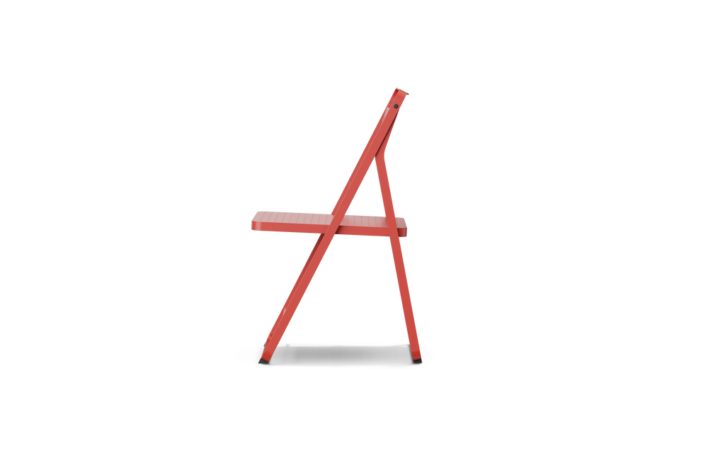 Neighbor Take Two Bistro Chair, an all-metal folding chair with perforated steel seat and backrest in coral red, side profile view.