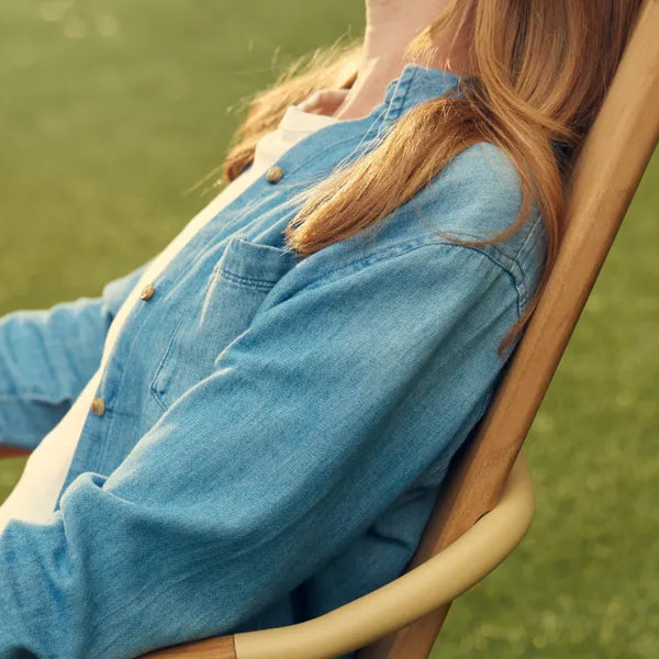 Person leaning back in Hopper Chair on grass, showing reclined seating angle and comfort position
