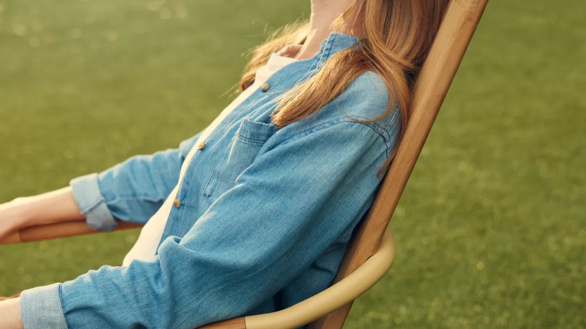 Person leaning back in Hopper Chair on grass, showing reclined seating angle and comfort position