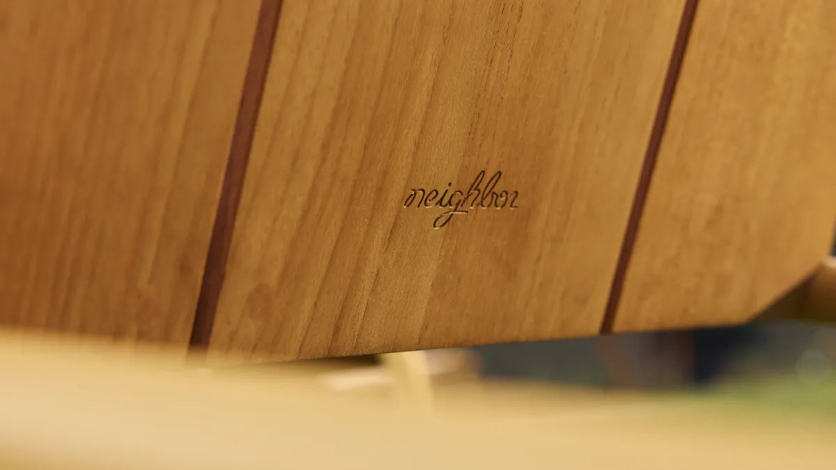 Close-up of Hopper Chair's solid wood seat and metal frame connection, highlighting durable construction detail