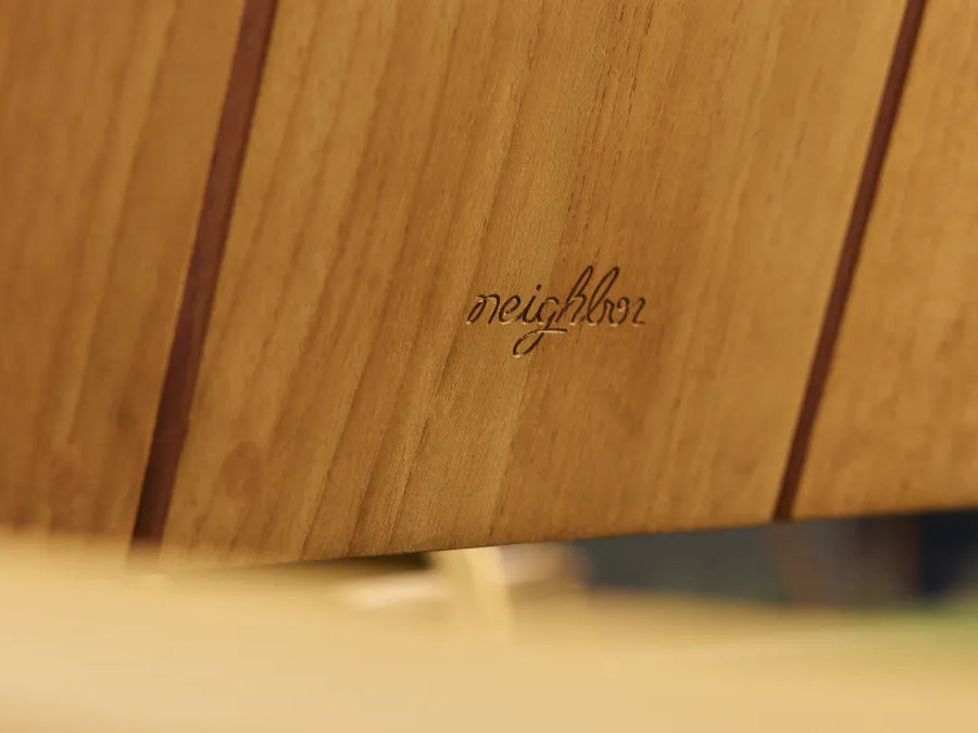 Close-up of Hopper Chair's solid wood seat and metal frame connection, highlighting durable construction detail