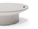 Neighbor Brim Fire Table in Stone, close-up of the pale gray cover resting on the fire bowl rim above the cylindrical base.