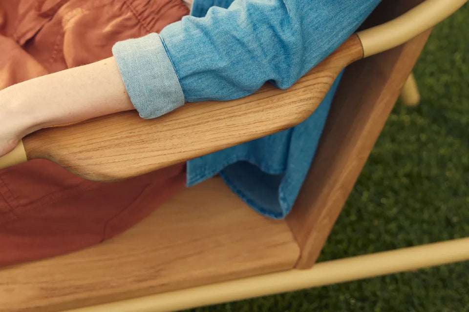 Person relaxing in Hopper Chair on grass with feet up on Ottoman, demonstrating lounge functionality
