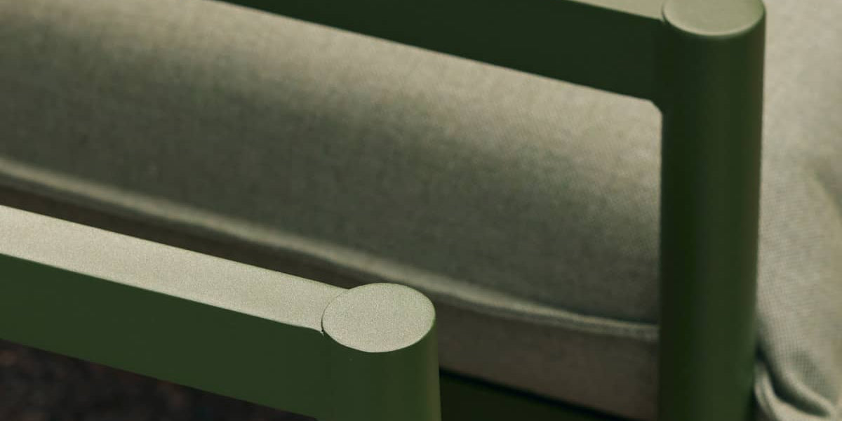 Closeup of aluminum armrests from a portion of a stylish green outdoor sofa