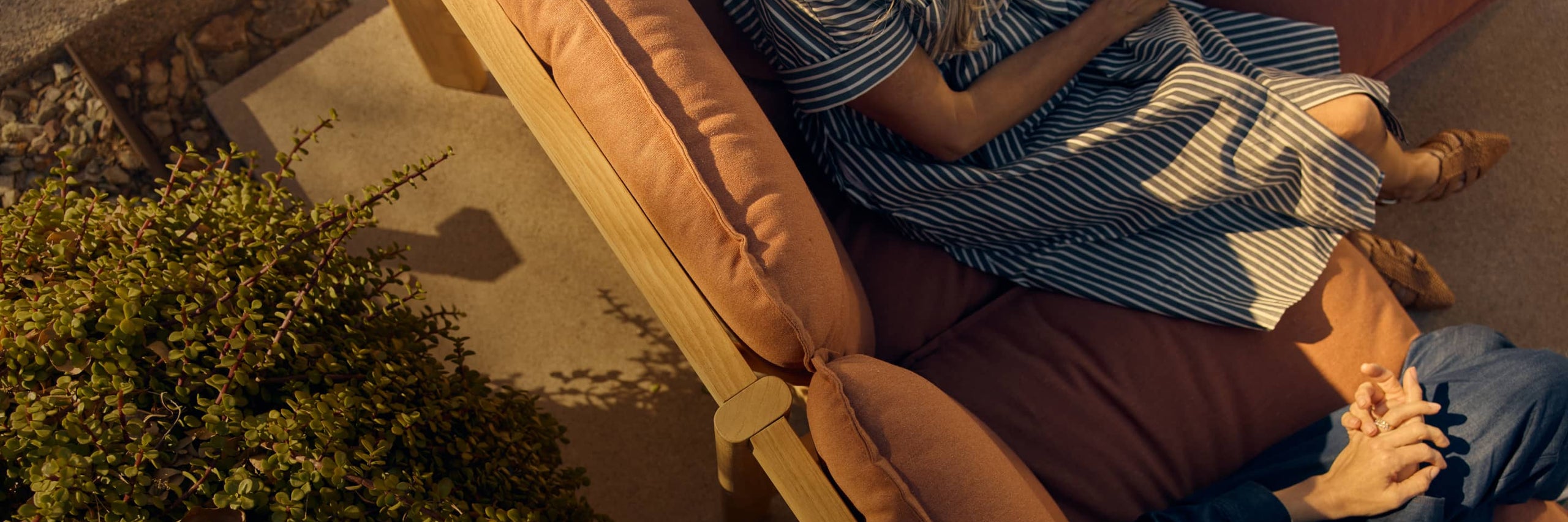 Overhead image of two women sitting and relaxing on an outdoor sectional