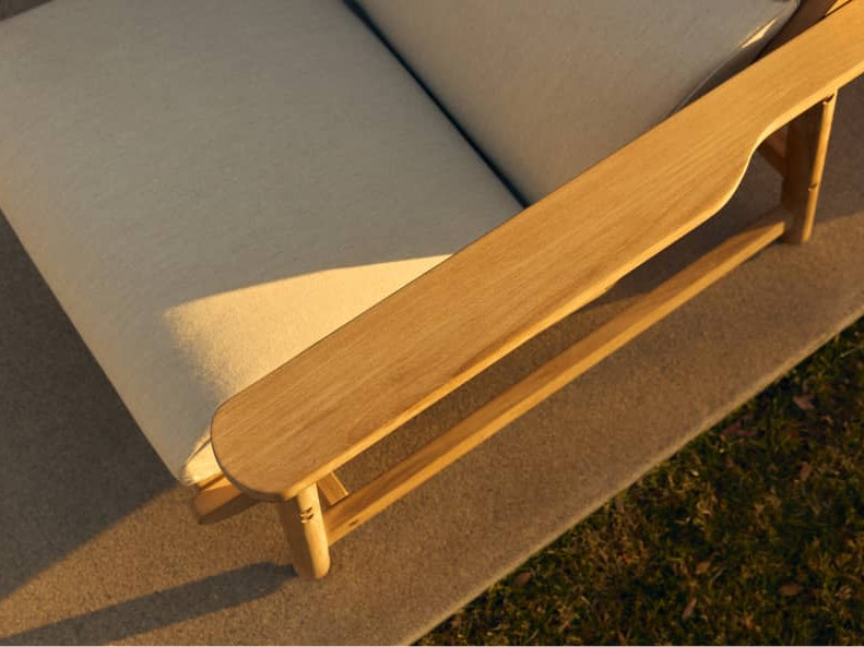 Close detail of the Leedo Deck Chair's teak armrest and Sunbrella fabric