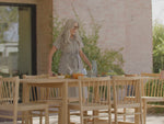 Video of a teak, outdoor dining set. Featuring the Neighbor Felloe Dining Set. S wide-planked, solid teak outdoor dining table and all-wood teak dining chair with wooden dowels.