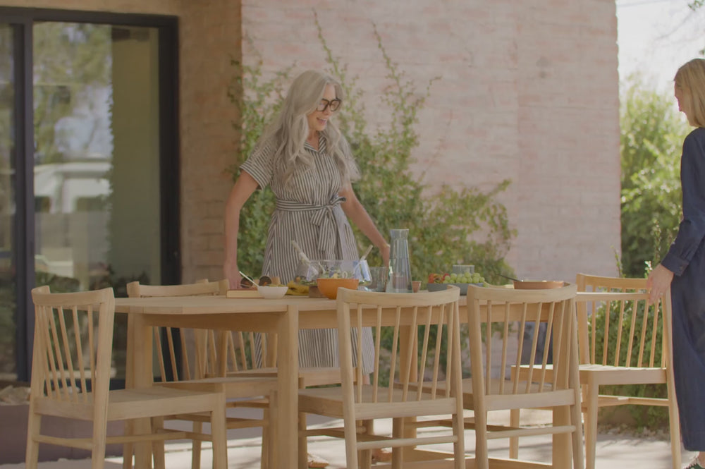 Video of a teak, outdoor dining set. Featuring the Neighbor Felloe Dining Set. S wide-planked, solid teak outdoor dining table and all-wood teak dining chair with wooden dowels. 