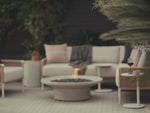 Video of light grey fire table with lava rock and flame burning.