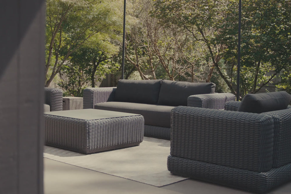 Video of charcoal synthetic rattan furniture, focusing on a chair with dark charcoal cushions. 