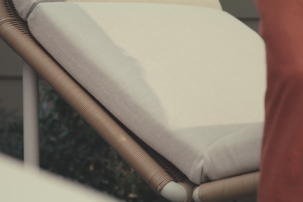Video of synthetic rattan chaise lounge outdoor chair with off-white cushions. 